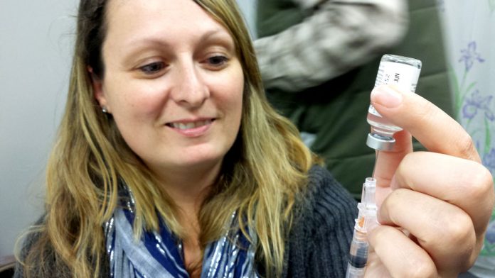 Public health nurse administers flu shot: Government of Alberta