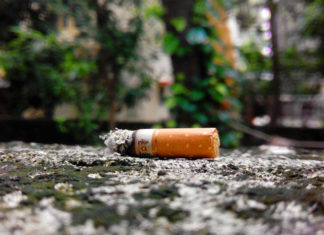 Discarded cigarette butt on pavement
