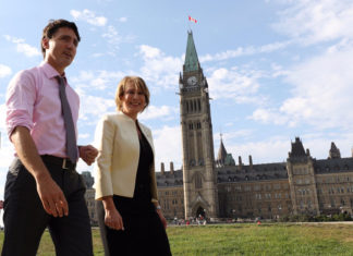 Prime Minister Justin Trudeau walks with Chief Science Advisor Mona Nemer in front of Canada's parliament