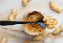 Spoon of peanut butter surrounded by monkey nuts