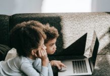 Two children looking at a laptop.