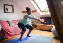 A person doing squats in their living room.
