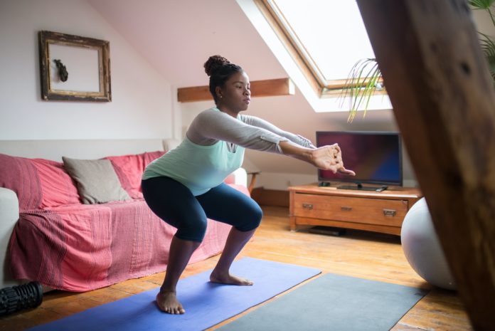 A person doing squats in their living room.