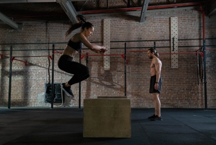 Two people exercising in a gym.
