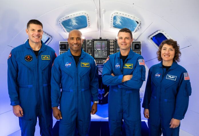 Canadian Space Agency astronaut Jeremy Hansen stands inside a model of the Orion spacecraft with his Artemis II crewmates: NASA astronauts Victor Glover, Reid Wiseman, and Christina Hammock Koch.