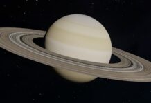 An image of Saturn. It is a pale yellow planet surrounded by a wide system of rings.