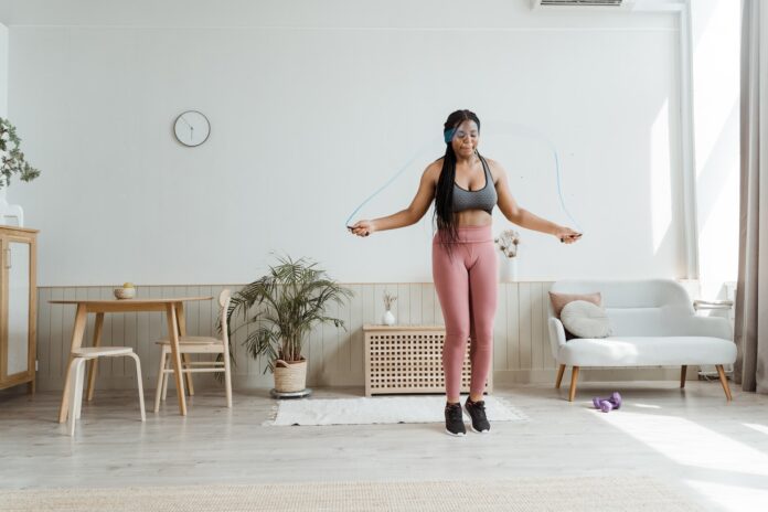 A woman skipping rope in her home.