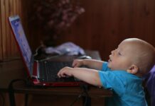 A baby looking at a laptop.